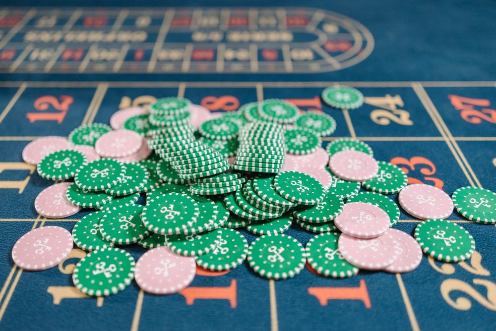 Tumpukan chip poker warna-warni di meja permainan