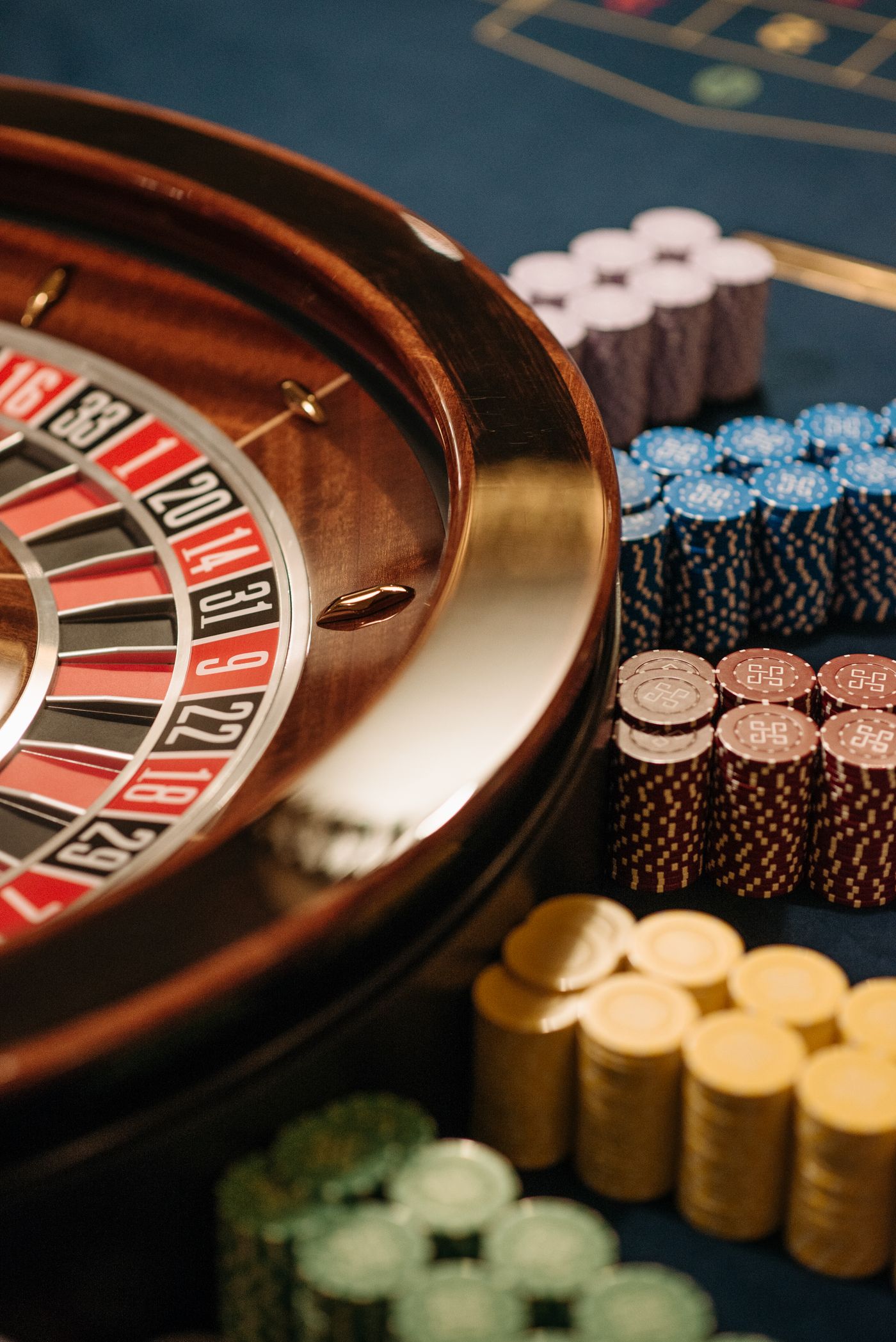 Meja roulette dan tumpukan chip kasino sebagai ilustrasi panduan Bolaslot88