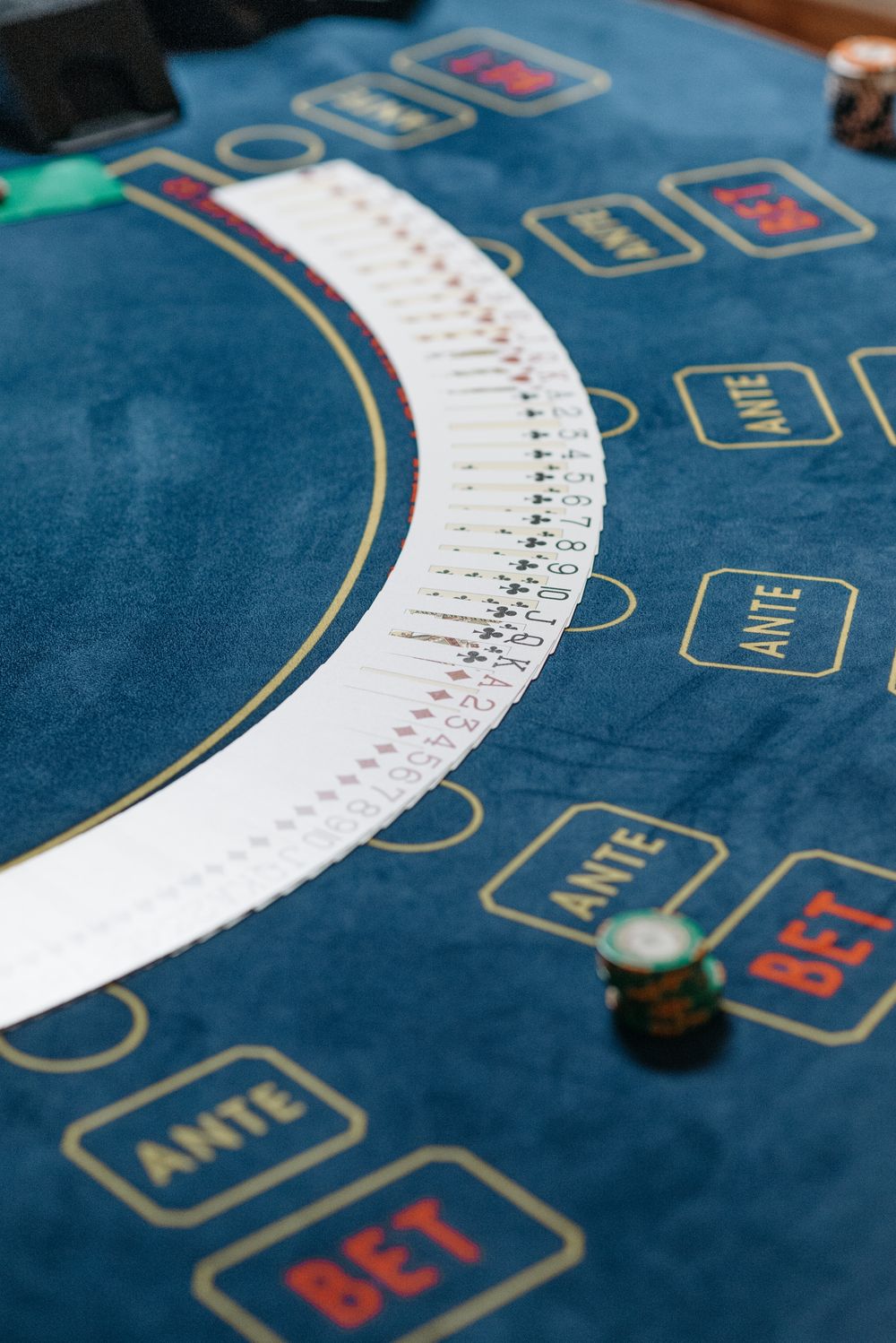 Kartu remi tersebar di atas meja poker berserta tumpukan chip